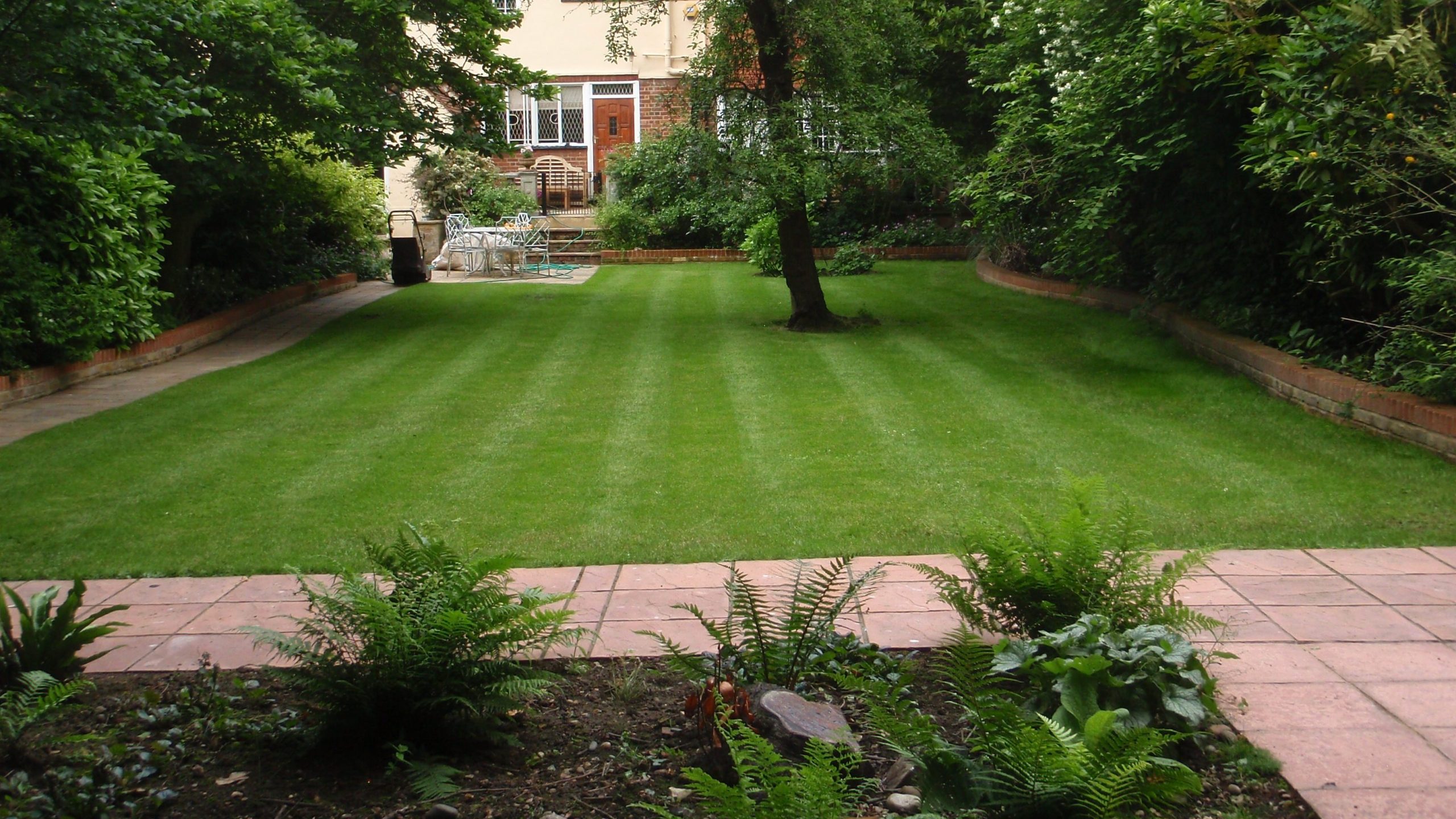 Mowed lawn with a tidy flowerbed in the foreground.